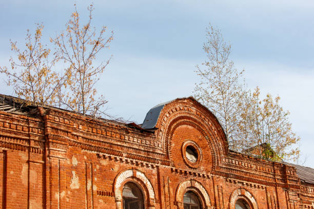 A brick building with a window in the middle of the front. The building is old and has a lot of cracks