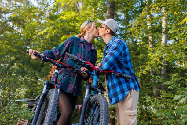 istock Couple kissing while riding bicycles in nature 2184026894