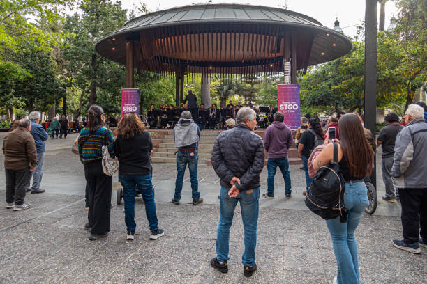 An audience watching band performing in the canopied bandstand in Plaza de Armas in central Santiago, Chile