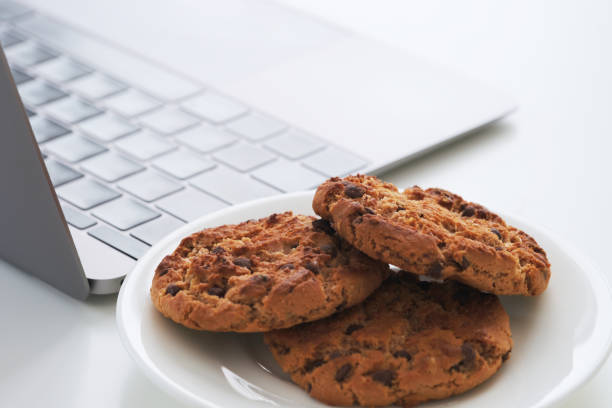 istock Chocolate chip cookies on a plate near a laptop 2184029899