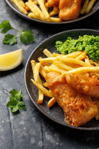 istock British Fish and chips with mashed peas, tartar and ketchup sauce. 2184030353