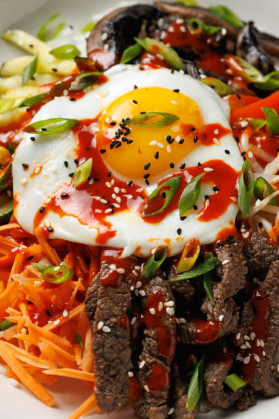 istock Traditional Korean dish Bibimbap with rice, vegetables beef and egg in a white plate 2184030358