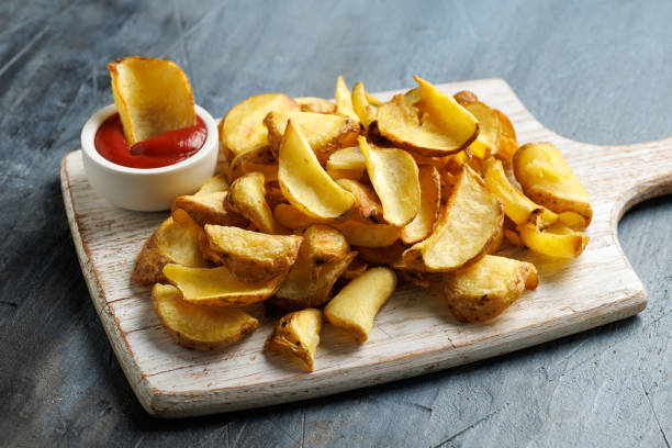 istock Fried potato dippers with ketchup on a white wooden board 2184030390