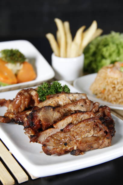 Tasty and Spicy Barbecue Pork Ribs with Grilled Vegetable on Wooden Cutting Board
