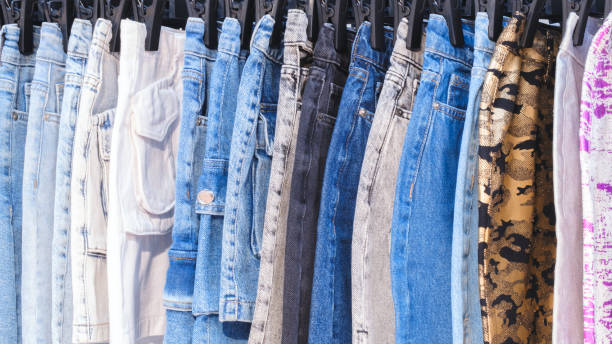istock A row of jeans with different colors and patterns. The jeans are hanging on a rack 2184039010