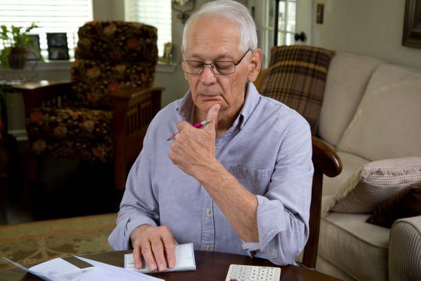 istock Senior man contemplating what bill to pay 2184045873