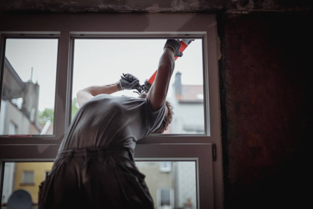 istock One young builder is repairing a window frame from the outside. 2184054582