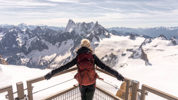istock Mountain woman with red backpack looking at snowy mountain 2184057670