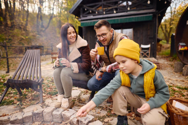 istock Family Enjoying a Cozy Campfire in Autumn Forest 2184061136