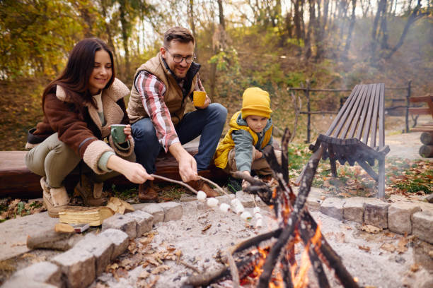 istock Family Enjoying Campfire in Autumn Forest Roasting Marshmallows 2184061162