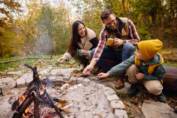 istock Family Enjoying Campfire in Autumn Forest Roasting Marshmallows 2184061165