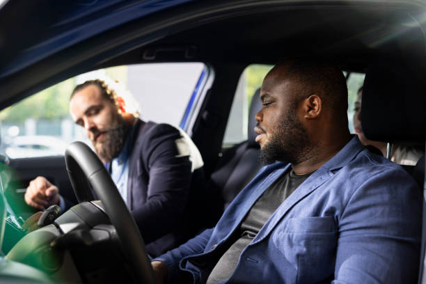 istock Client driving car to evaluate it, talking with showroom worker 2184068045