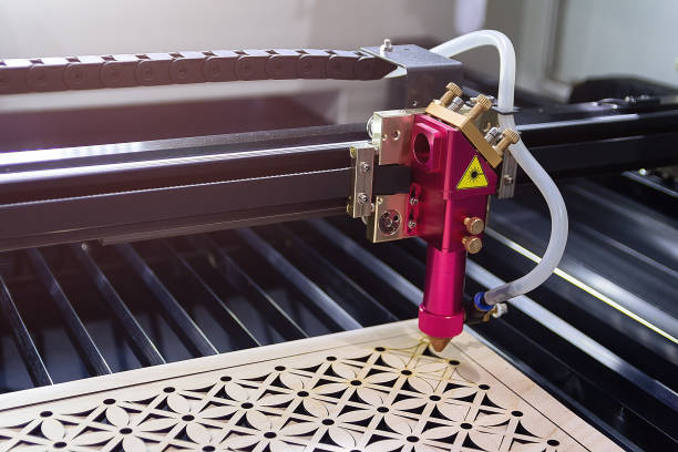 Laser engraving machine carves a design on a wooden surface