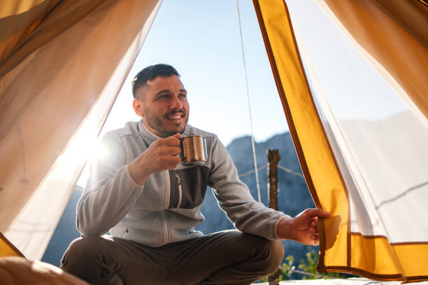 istock Man Enjoying a Morning Coffee in a Camping Tent 2184069236