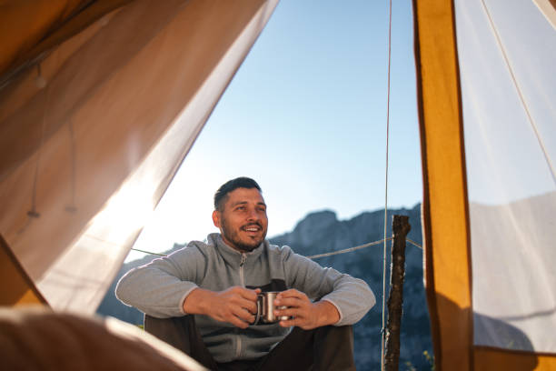 istock Smiling Camper Enjoying Morning Coffee in Tent with Mountain View 2184069239