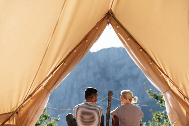 istock Couple Relaxing Inside Tent with Scenic Mountain View 2184069275