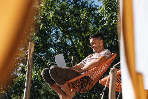 istock Man Relaxing Outdoors With Laptop in Relaxed Summer Setting 2184069296
