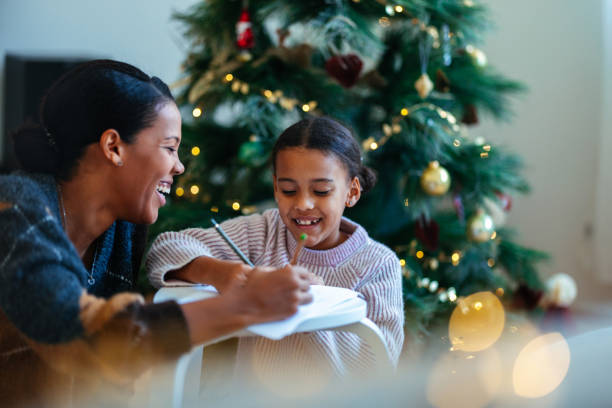 istock Mother and Daughter Enjoying Christmas Together by Tree 2184072633