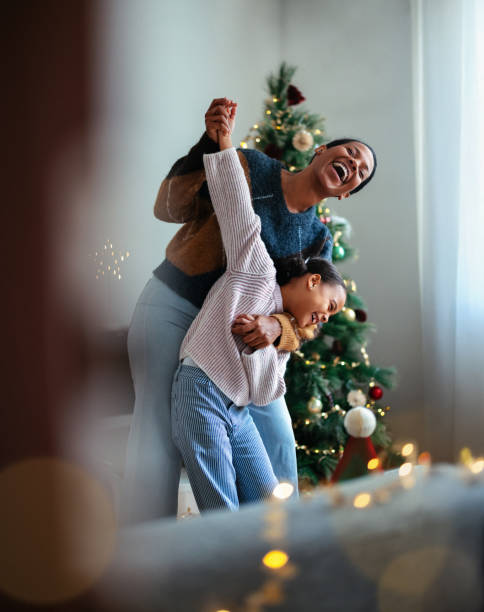 istock Joyful Mother and Daughter Dancing Near a Christmas Tree 2184072667