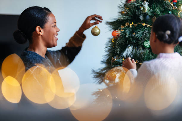 istock Mother and Daughter Joyfully Decorating Christmas Tree Together 2184072670