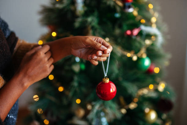 istock Hands Decorating Christmas Tree with Red Ornament 2184072693