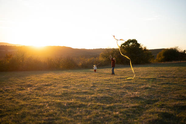 Mother helps her son assemble a toy kite, promoting an active lifestyle and outdoor fun, bonding through shared activities.