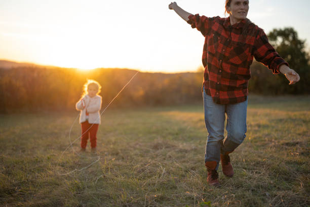 istock Family Flying Kite in Nature at Sunset. 2184074172