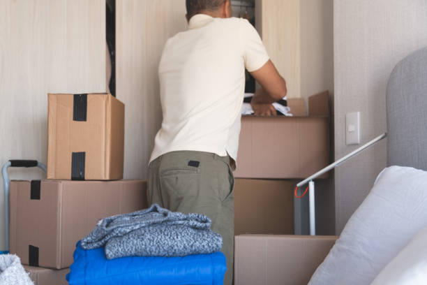 istock A man is standing in a room with boxes and clothes. New home concept. 2184074760