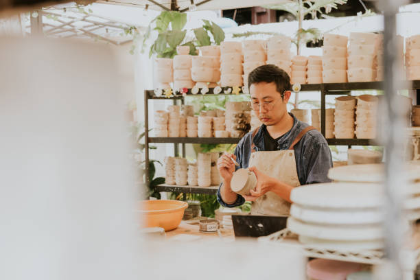 istock Southeast Asian craftsperson is painting bowl at studio. 2184076035