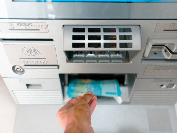 istock A man withdraws money from an ATM automated teller machine. 2184077356