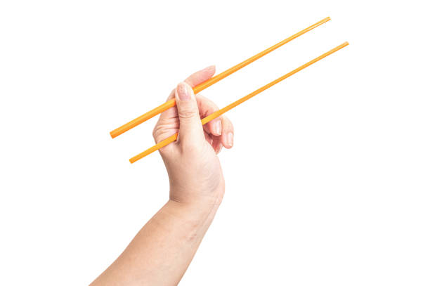istock Female hand holding a orange plastic chopstick isolated on white background. 2184083502