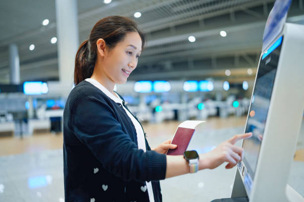 istock Young Woman Using Self-Service Kiosk for Airport Check-In 2184087554