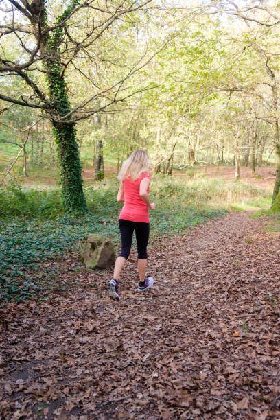 istock woman exercising in the forest 2184089474