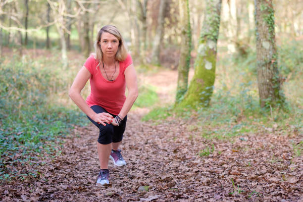 istock woman exercising in the forest 2184089908