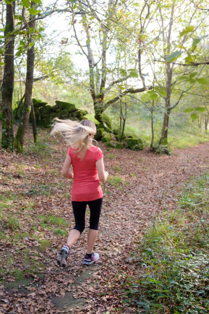 istock woman exercising in the forest 2184089915