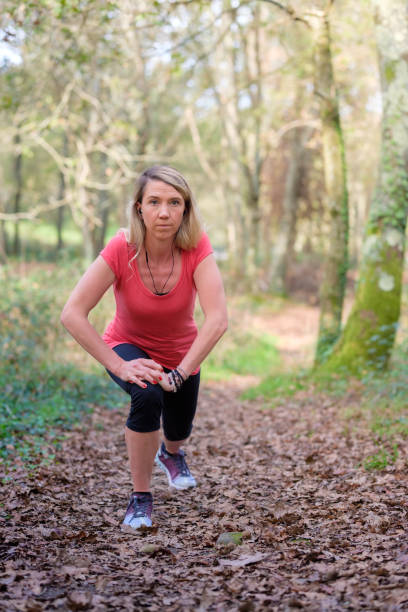 istock woman exercising in the forest 2184090199