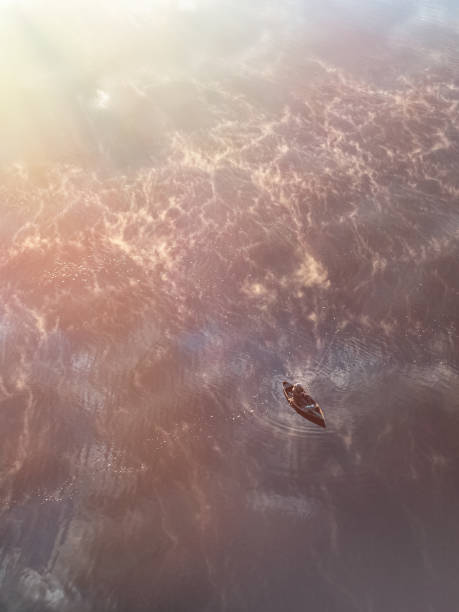 istock Enjoy a Serene Sunset Glowing Over Tranquil Waters While Observing a Small Boat Gliding Smoothly 2184091594