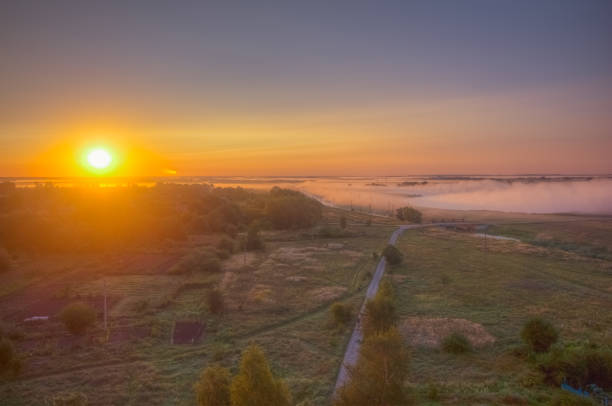 A breathtaking stunning sunrise beautifully casts its golden light across a serene and misty landscape