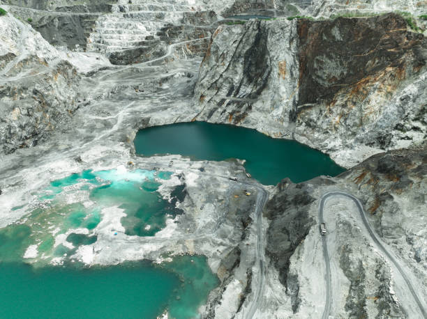 istock Large limestone quarry operation. Industrial trucks working at open pit mining site with striking turquoise water. Resource extraction process. Mining operation in limestone quarry. Industrial scale. 2184093658