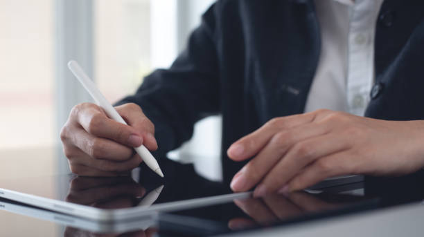istock Close up, business woman using stylus pen signing e-document on digital tablet via mobile app at office, e-signing, Businesswoman working and surfing the internet, on digital tablet pc 2184094503