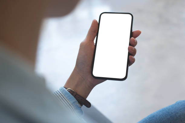 istock Mockup, woman's hands holding mobile phone with blank screen in coffee shop, over shoulder view 2184095818