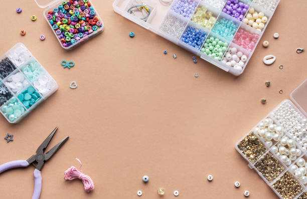 istock Crafting with colorful beads on a flat workspace with tools and containers in bright daylight 2184099885