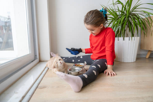 istock Heartwarming interactions between children and their pets, showing the responsibilities, compassion and learning experiences involved in pet care. Mutual love and trust between children and their furry friends. Pet feeding, grooming, bonding moments. 2184102861