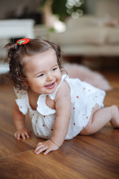 istock Cute baby crawling on floor at home 2184103885