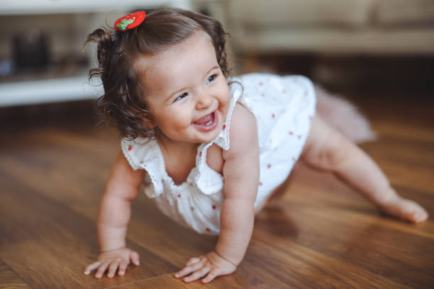 istock Cute baby crawling on floor at home 2184103931