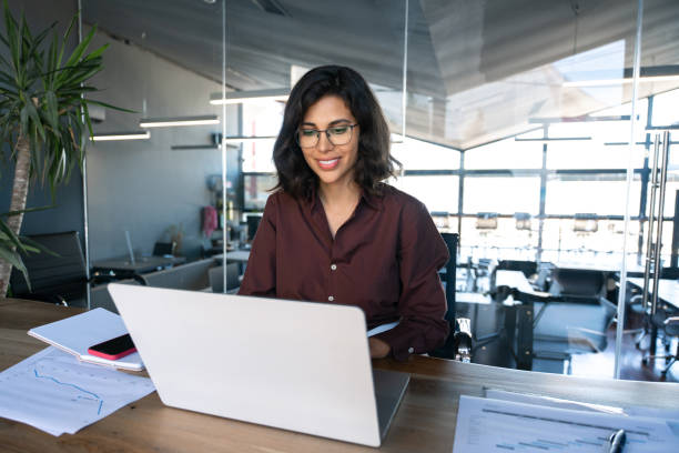 istock Smiling young middle eastern business woman specialist working focused on laptop computer. Middle aged latin hispanic investor, bank worker using pc for analysing, network at workplace desk in office 2184105558