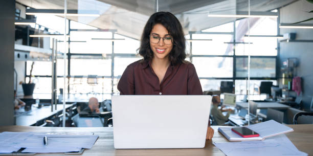 istock Young businesswoman professional employee using pc doing online banking analysing at workplace. Latin hispanic middle age business woman working on laptop computer in modern office. Banner, copy space 2184105588