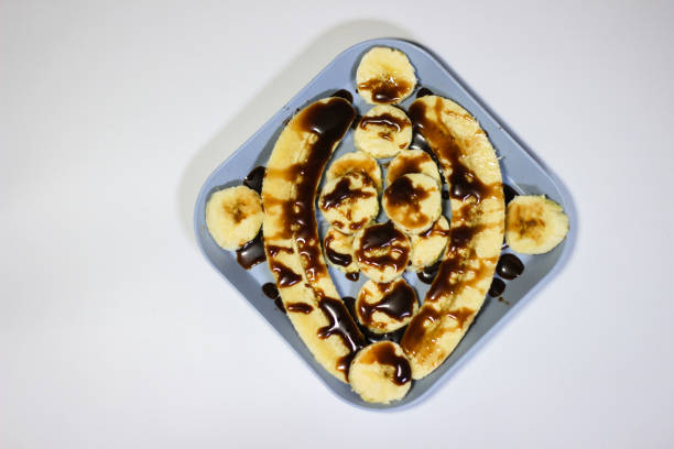 fresh ripe banana with chocolate sauce on white background