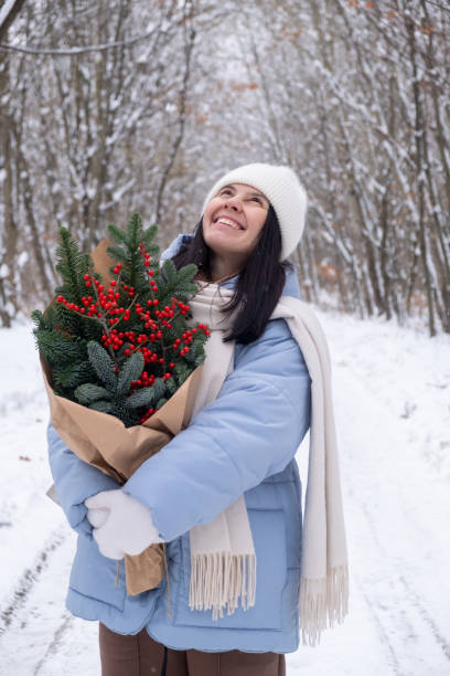 istock Person Holding Bouquet on Snowy Forest Path 2184106891
