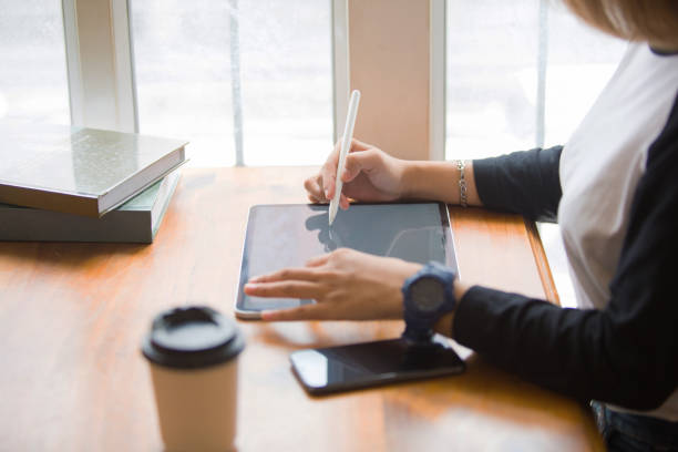 istock Closeup shot of business woman's hand using pen and writing in computer 2184108093